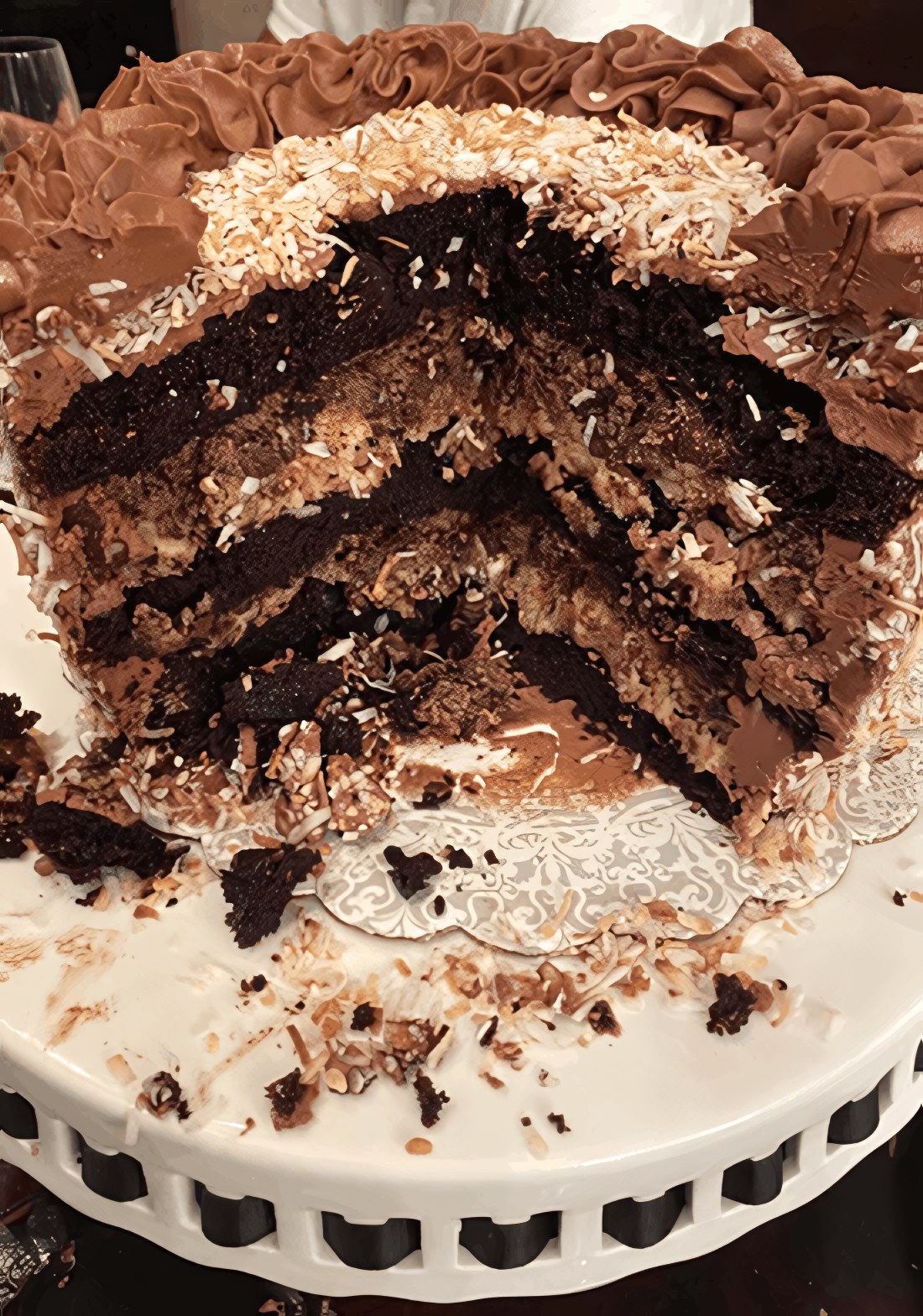 A chocolate layer cake made by Little Hidden Bakery, cut to show its layers and finished with toasted coconut